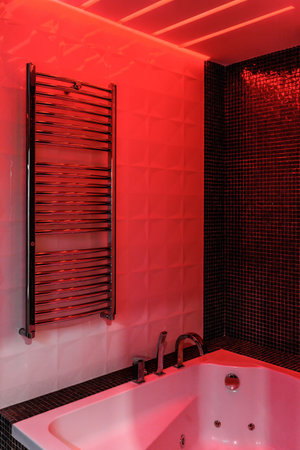 Modern bathroom with freestanding bathtub, modern taps and red LED ambient lighting.の写真素材