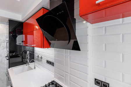 Modern kitchen interior with red and black cabinets and white ceramic floorの写真素材
