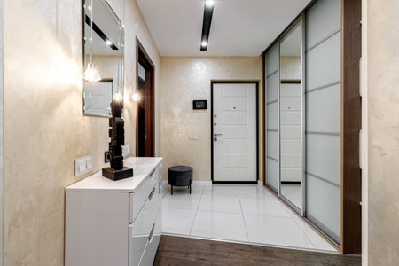 Entrance hall in the apartment with a large wardrobe with a mirror, soft pouf and other furnitureの写真素材