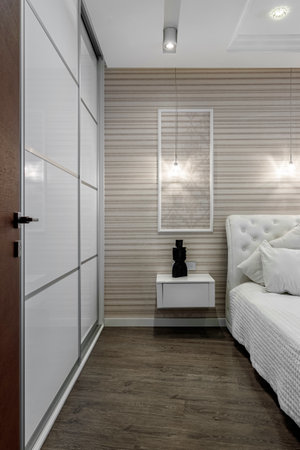 Bright bedroom with large white bed and capitone headboardの写真素材
