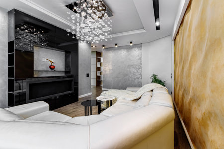 Living room with white walls and a huge white sofa, a black glossy wardrobe with a large yellow 3D panel on the wall as well as bio fireplaces.の写真素材