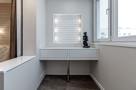 Modern interior of the loggia of white color with lighting, table and window.の写真素材