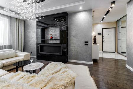 Black bio fireplace in the living room with large crystal chandelier in the apartmentの写真素材