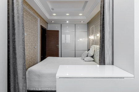 Bright bedroom with large white bed and capitone headboardの写真素材