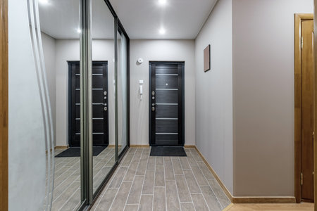 long corridor in interior of entrance hall of modern apartments with doors, cabinets, shelves and a mirror.の写真素材