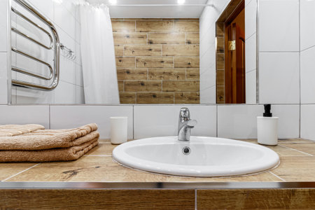 White sink and huge mirror in a modern bathroom in a small apartment.の写真素材