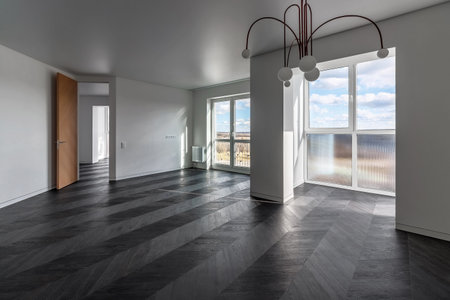 Empty apartment with large floor-to-floor window overlooking nature and blue sky with clouds.の写真素材