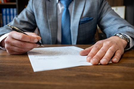 Close up business man reaching out sheet with contract agreement proposing to sign. Full and accurate details, individual who owns the business sign personally, director of the company, solicitor.の写真素材