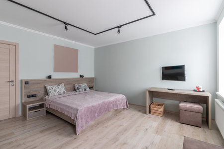 Hotel room with a large double bed in light colors.の写真素材