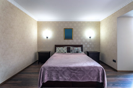 Hotel room with a large double bed in light colors.の写真素材