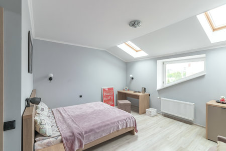 Hotel room with a large double bed in light colors.の写真素材