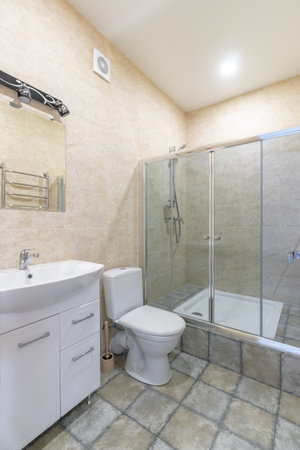 Bathroom in a small family hotel with shower, toilet and sink.の写真素材