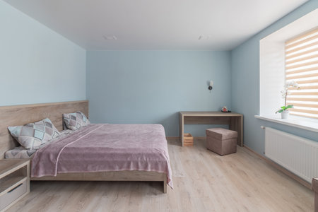 Hotel room with a large double bed in light colors.の写真素材