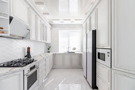 Modern interior with white kitchen and kitchen appliances in the country house.の写真素材