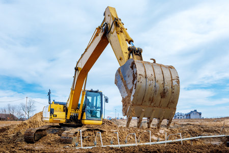 Excavator dig the trenches at a construction site. Trench for laying external sewer pipes. Sewage drainage system for a multi-story building. Digging the pit foundation.の写真素材