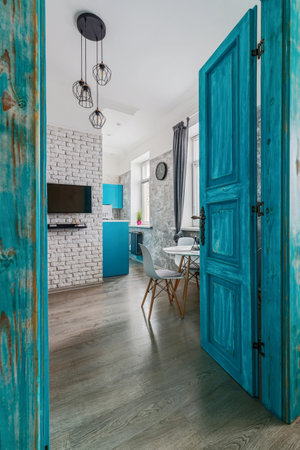 The interior of the apartment is in the old style, with high ceilings and an old wooden door of turquoise color.の写真素材