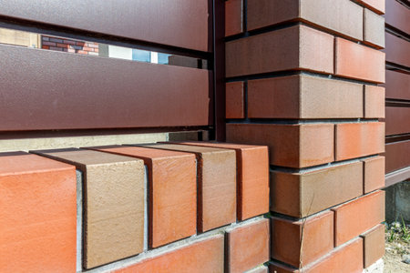 Fragment of a modern fence lined with decorative bricks in the old style.の写真素材