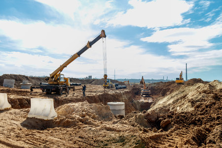 Connecting a trench drain to a concrete manhole structure at construction site. Concrete pile in formwork frame for construct stormwater and underground utilities, pump stations, sewers pipes.の写真素材