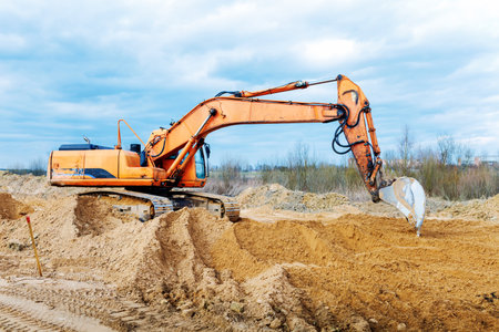 Excavator dig the trenches at a construction site. Trench for laying external sewer pipes. Sewage drainage system for a multi-story building. Digging the pit foundation.の写真素材