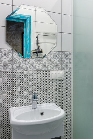 Bathroom with white tiles, mirror and washbasin.の写真素材