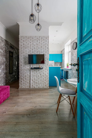 The interior of the apartment is in the old style, with high ceilings and an old wooden door of turquoise color.の写真素材