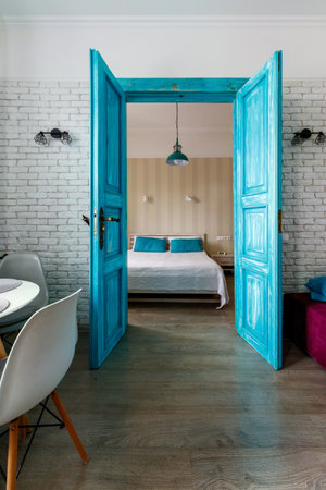 The interior of the apartment is in the old style, with high ceilings and an old wooden door of turquoise color.の写真素材