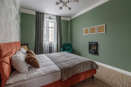 Bedroom in retro style with bed, old wardrobe and green wallsの写真素材