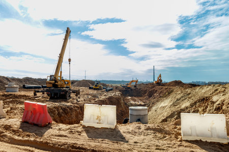 Connecting a trench drain to a concrete manhole structure at construction site. Concrete pile in formwork frame for construct stormwater and underground utilities, pump stations, sewers pipesの写真素材