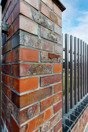 Fragment of a modern fence lined with decorative bricks in the old style.の写真素材