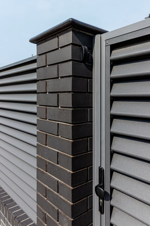 Fragment of a modern fence lined with decorative bricks in the old style.の写真素材