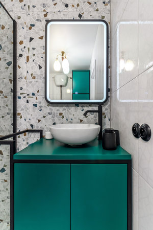 Bathroom with turquoise furniture, black faucets and showerの写真素材