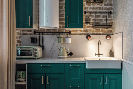 Modern retro-style kitchen with green cabinets and brick wallsの写真素材