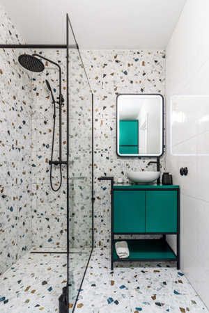 Bathroom with turquoise furniture, black faucets and shower.の写真素材