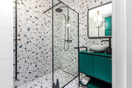 Bathroom with turquoise furniture, black faucets and shower.の写真素材
