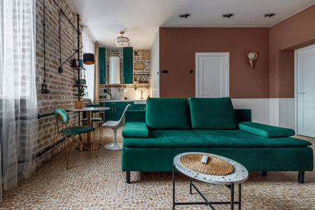 Stylish living room in house with modern retro interior design, velvet sofa, plants, poster mock up map, book, lamp and perosnal accessories in home decorの写真素材
