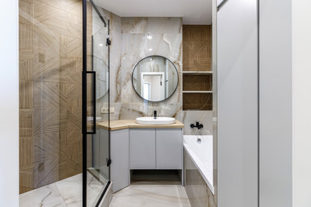 Modern bathroom with black fixtures, mirror and white sink.の写真素材