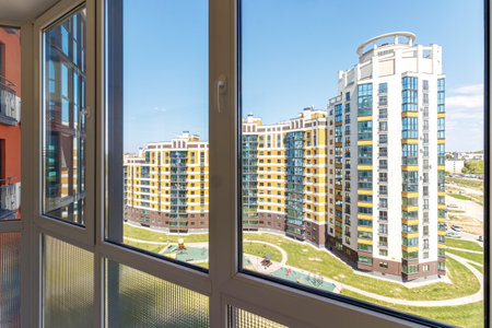 View through the huge balcony window to the park area and other houses.の写真素材