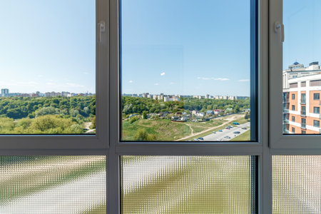 View through the huge balcony window to the park area and other houses.の写真素材