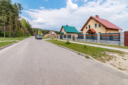 New small house against the blue sky with asphalt road and green grassの写真素材