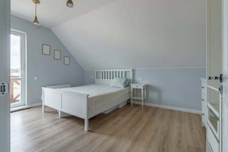 Modern bedroom in a new house in bright colors with a minimum amount of furnitureの写真素材