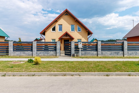 New small house against the blue sky with asphalt road and green grass.の写真素材