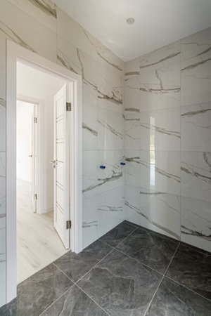 Bathroom with tiled walls before installing shower and sink, is in the apartment that is under constructionの写真素材