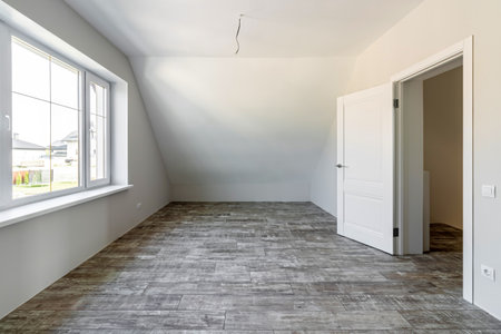 A room in a private house immediately after laying the floor, white unfinished walls and ceiling.の写真素材