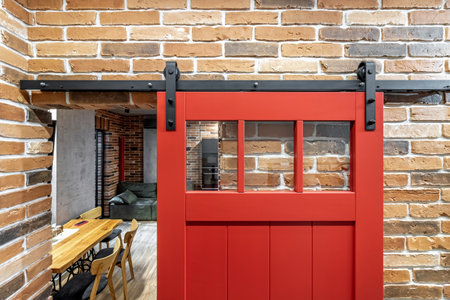Apartment interior with sliding red door and clay red brick wall decoration.の写真素材