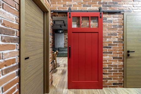 Apartment interior with sliding red door and clay red brick wall decoration.の写真素材