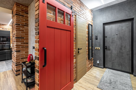 Apartment interior with sliding red door and clay red brick wall decoration.の写真素材
