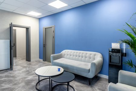 Gray doors with glass insert in office space with blue wall and comfortable sofa.