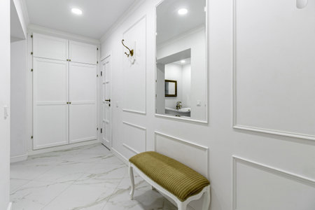 White entrance hall interior with wooden banquette with gold top.の写真素材