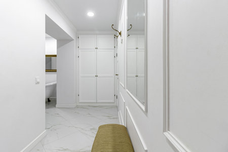 White entrance hall interior with wooden banquette with gold top.の写真素材