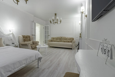 Interior in light colors with a bio fireplace, illuminated by burning sconces on the wall.の写真素材